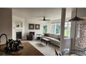 Bright living room features a fireplace, ceiling fan, and large windows offering natural light at 14232 Piney River Rd, Broomfield, CO 80023