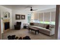 Bright living room features a fireplace, ceiling fan, and large windows offering natural light at 14232 Piney River Rd, Broomfield, CO 80023