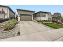 Modern home showcasing a spacious driveway, manicured lawn, and rock landscaping at 2105 Bellcove Dr, Castle Pines, CO 80108