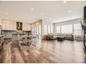 Open-concept living room with hardwood floors, large windows, modern lighting, and fireplace at 2105 Bellcove Dr, Castle Pines, CO 80108