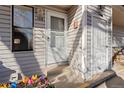Detailed entrance of unit 106 with a white storm door and wood-tone trim at 8701 Huron St # 5-210, Thornton, CO 80260