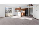 Open-concept living and kitchen area with carpet flooring and sliding glass door at 8701 Huron St # 5-210, Thornton, CO 80260