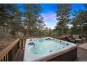 Relaxing hot tub on a wooden deck surrounded by mature trees and scenic views at 2386 Daisy Ln, Golden, CO 80401