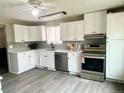 Bright kitchen with white cabinetry, stainless steel appliances, and modern countertops at 1088 Douglas Dr, Denver, CO 80221