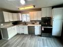Modern kitchen with white cabinets, stainless steel appliances, and gray tile backsplash at 1088 Douglas Dr, Denver, CO 80221