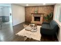Cozy living room with wood-burning fireplace, dark wood floors, and stylish seating arrangement at 1088 Douglas Dr, Denver, CO 80221