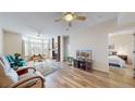 Bright and airy living room with fireplace, ceiling fan, and light hardwood floors at 2897 W Riverwalk Cir # 204, Littleton, CO 80123