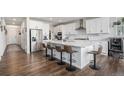 Modern kitchen featuring white cabinets, stainless steel appliances, and a large island with bar seating at 1408 Brookfield Pl, Lafayette, CO 80026
