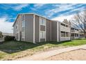 Condo building exterior featuring gray siding and well-kept landscaping at 18071 E Kentucky Ave # 203, Aurora, CO 80017