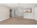 Inviting living room open to the kitchen with neutral paint and carpet at 18071 E Kentucky Ave # 203, Aurora, CO 80017