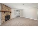 Spacious living room with a stone fireplace and sliding glass door to the balcony at 18071 E Kentucky Ave # 203, Aurora, CO 80017