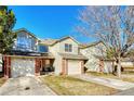 A row of townhouses featuring brick facades, well-maintained lawns, and attached two-car garages at 15925 E 13Th Ave, Aurora, CO 80011
