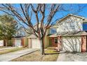 Inviting townhouse showcasing a well-kept lawn, brick accents, and a convenient two-car garage at 15925 E 13Th Ave, Aurora, CO 80011