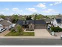 Aerial view of a brick home with a large driveway, three-car garage, and well-maintained landscaping at 5708 Wetland Loop, Frederick, CO 80504