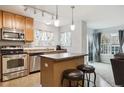 Well-lit kitchen with stainless steel appliances, island with seating, and direct view to the living area at 23535 E Platte Dr # A, Aurora, CO 80016