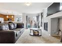 Bright living room featuring a cozy fireplace, plush carpet, and sliding door access to outdoor space at 23535 E Platte Dr # A, Aurora, CO 80016