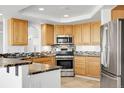 Well-appointed kitchen with stainless steel appliances and plenty of wood cabinetry for storage at 44000 E 88Th Ave, Bennett, CO 80102