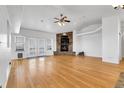 Open living room featuring hardwood floors, fireplace, and glass doors for bright, inviting living at 44000 E 88Th Ave, Bennett, CO 80102