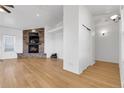 Bright living room with hardwood floors and a stone fireplace adding cozy charm at 44000 E 88Th Ave, Bennett, CO 80102