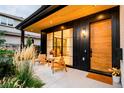 Inviting front porch with wood accents, modern lighting, and decorative outdoor seating arrangement at 1983 S Logan St, Denver, CO 80210