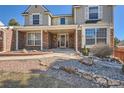 Charming front porch with brick accents and landscaped garden with decorative rock at 4240 S Yukon Way, Lakewood, CO 80235