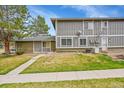 Exterior featuring a well-maintained lawn, mature trees, and a view of the side of the home at 1212 S Uvalda St, Aurora, CO 80012