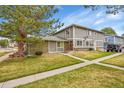 Exterior featuring a well-maintained lawn, mature trees, and the front of the home at 1212 S Uvalda St, Aurora, CO 80012