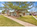 Inviting exterior with a well-manicured lawn, mature trees, and cozy front patio at 1212 S Uvalda St, Aurora, CO 80012