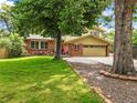 Charming home with a lush front lawn and mature trees providing ample shade at 12625 W 66Th Cir, Arvada, CO 80004