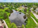 Scenic aerial view of neighborhood park with a serene pond and playground at 12625 W 66Th Cir, Arvada, CO 80004