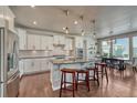 Bright, open kitchen featuring a large island with bar seating, modern appliances, and eat-in dining area at 23957 E Rocky Top Ave, Aurora, CO 80016