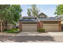 Front view of a two story townhome with double attached garage and landscaping at 4825 S Ammons St # 122, Littleton, CO 80123