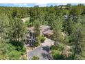 Luxury home nestled in a wooded area with a large driveway at 967 Country Club Pkwy, Castle Rock, CO 80108