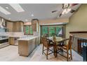 Open kitchen and dining area with large windows that provide beautiful wooded views at 8944 W 66Th Pl, Arvada, CO 80004