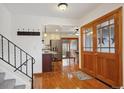 Inviting entryway featuring hardwood floors, stairs to upper level, and double-door access to outdoor patio at 4634 S Adobe Ct, Littleton, CO 80127