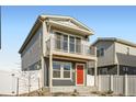 Charming two-story home with a balcony and a red front door with manicured landscaping at 5035 N Walden Way, Denver, CO 80249