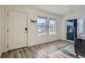 Bright living room with hardwood floors, large windows, and a sliding door for ample natural light at 5035 N Walden Way, Denver, CO 80249