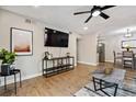 Modern living room open to kitchen and dining area with recessed lighting and hardwood floors at 7755 E Quincy # 201, Denver, CO 80237