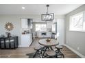 Modern eat-in kitchen featuring a dining table with seating, stainless steel appliances, and bright natural light at 4933 W 61St Ave, Arvada, CO 80003