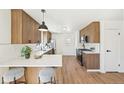 Stylish kitchen featuring a breakfast bar, stainless steel appliances, wood cabinets, and hardwood floors at 2295 S Sherman St, Denver, CO 80210