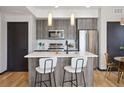 Modern kitchen featuring stainless steel appliances, white countertops, and island seating at 1277 Quitman St, Denver, CO 80204