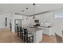 Kitchen featuring a large island, stainless steel appliances, granite countertops, modern lighting, and plenty of cabinet space at 27307 E Costilla Pl, Aurora, CO 80016