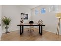 Office with hardwood floors, modern desk and decor, light walls and plenty of sunlight coming through the windows at 27307 E Costilla Pl, Aurora, CO 80016