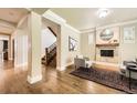 Bright living room with hardwood floors, cozy fireplace, and staircase; adjacent to a doorway and hallway at 1410 S Elizabeth St, Denver, CO 80210