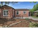 Beautiful brick home with tidy landscaping, featuring a well-maintained lawn and attached one car garage at 1111 Kearney St, Denver, CO 80220