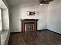 Bright living room featuring a fireplace, ceiling fan, and wood-look flooring at 8571 S Estes St, Littleton, CO 80128