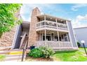 Charming condo building featuring stone accents, a covered porch, and well-maintained landscaping at 8335 Fairmount Dr # 10-208, Denver, CO 80247