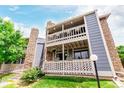 Charming condo building featuring stone accents, a covered porch, and well-maintained landscaping at 8335 Fairmount Dr # 10-208, Denver, CO 80247