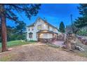 Beautiful home featuring stone accents, a brick patio, and an inviting entrance at 9310 S Watson Gulch Rd, Littleton, CO 80127