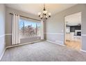 Dining room featuring a modern chandelier, new carpet, and large window at 11715 Crow Hill Dr, Parker, CO 80134